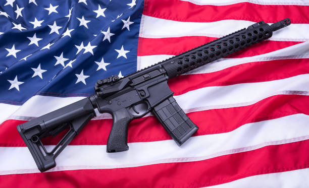 istock Custom built AR-15 carbine on American flag surface, background. Studio shot. 956667068