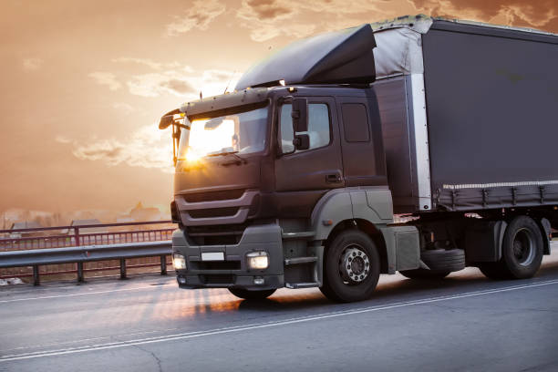 istock truck goes on highway on sunset 956672218