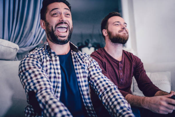 istock Two Excited Screaming Friends Playing Video Games 956675160