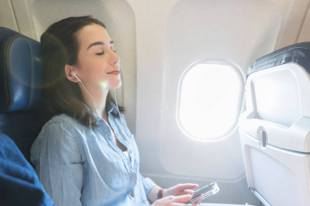 mujer joven se relaja durante el vuelo - silla al lado de la ventana fotografías e imágenes de stock