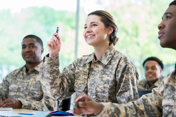 istock Cheerful female soldier asks question in college class 956729728