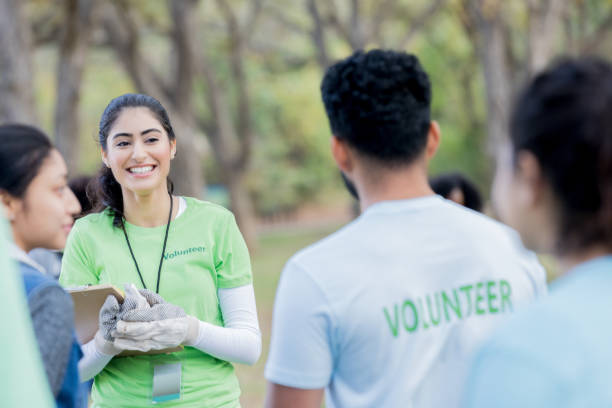 istock Young female volunteer coordinator speaks to group 956732802