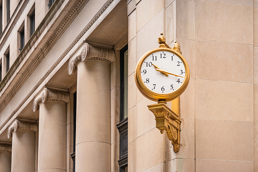 Stock photograph of a golden colored clock in the Financial District of Boston Massachusetts USA.
