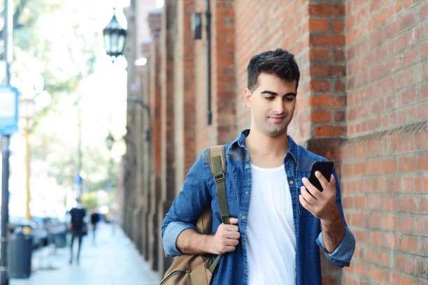 istock Latin man typing on his phone. 956737950
