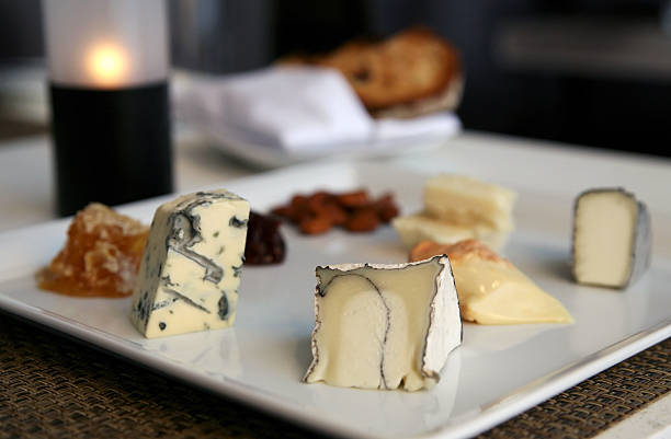 Delicious assortment of cheeses, smoked nuts, raisins and honeycomb stock photo