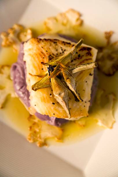 Sea bass on a bed of purple potato puree stock photo