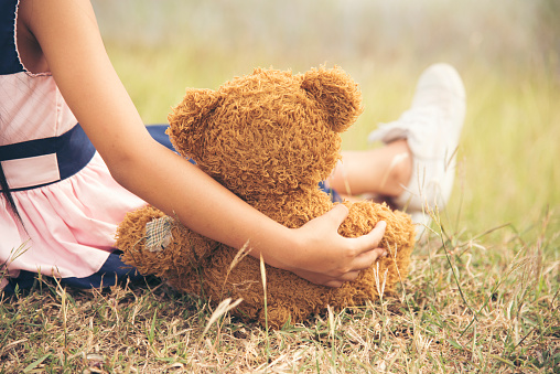 little girl hugging a fluffy teddy bear