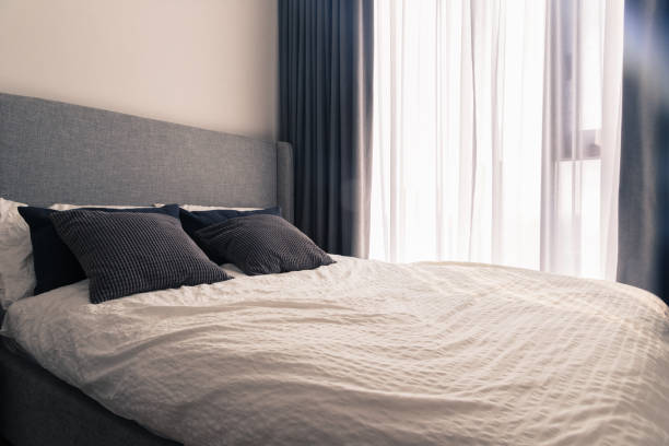 istock King size bed in narrow bedroom, daylight. 956747672