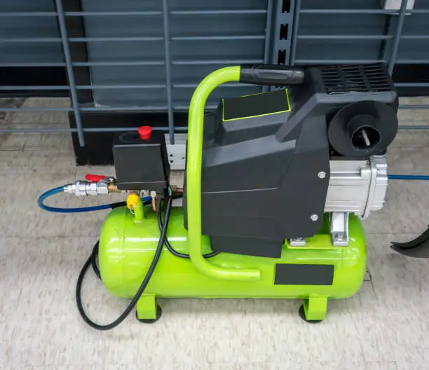 Bright green portable air compressor and accessories for indoor use.