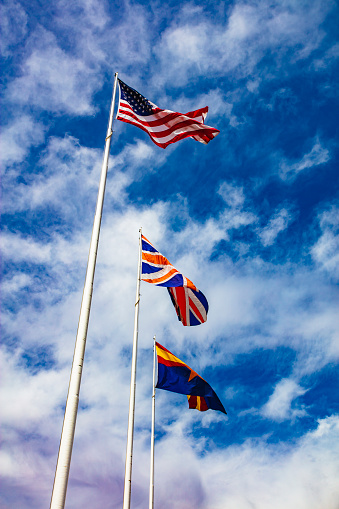 A stock photo showing 3 flags on London Bridge in Lake Havasu City, Arizona. Showing the USA flag, the State of Arizona flag and the UK Union Jack flag.