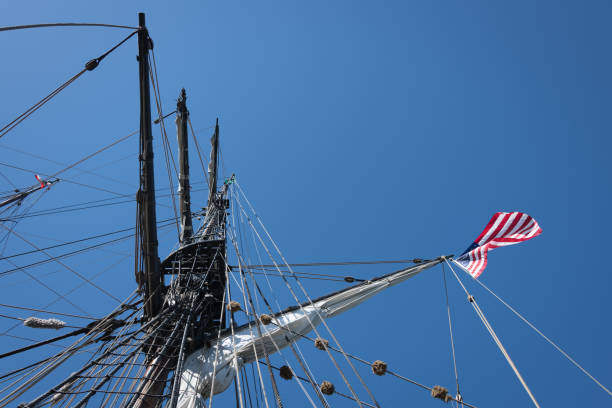 Mizzen Mast, Spanker Gaff and American Flag Low angle view up a wooden mizzen mast on a 19th century wooden tall ship. American flag flies from the spanker gaff. gaff rigged stock pictures, royalty-free photos & images