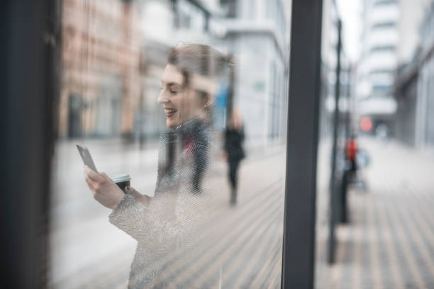 istock Woman using smart phone and waiting for the bus 956773568