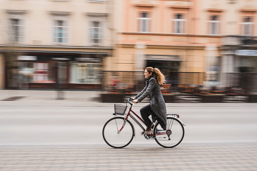 Businesswoman riding with a bike in the city