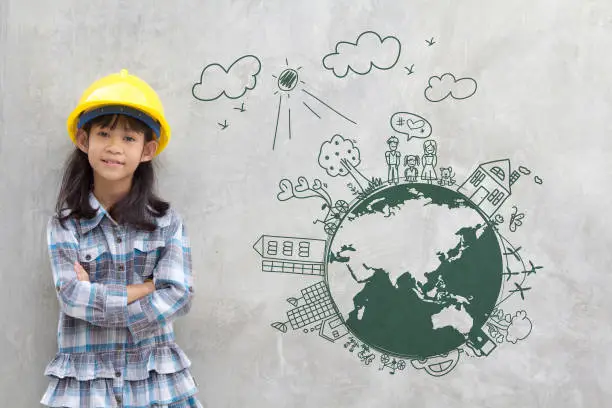 Photo of Little girl engineering with creative drawing on world map environment with happy family, eco friendly, save energy, against a brick wall