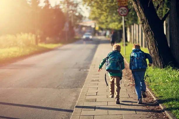 Two school boys running on sidewalk on way to school. Sunny day morning.
Shot with Nikon D850