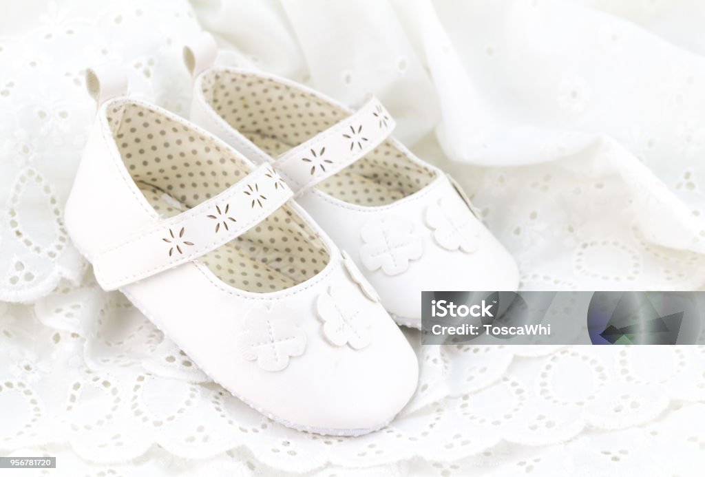 Baby white baptism or birthday dress and shoes close up with space for text Baptism Stock Photo