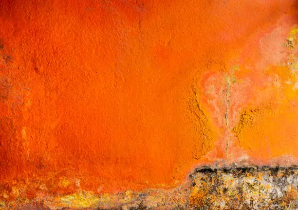 Photo of Old and dirty orange color painted on concrete wall texture background with space. Fungus on the house wall