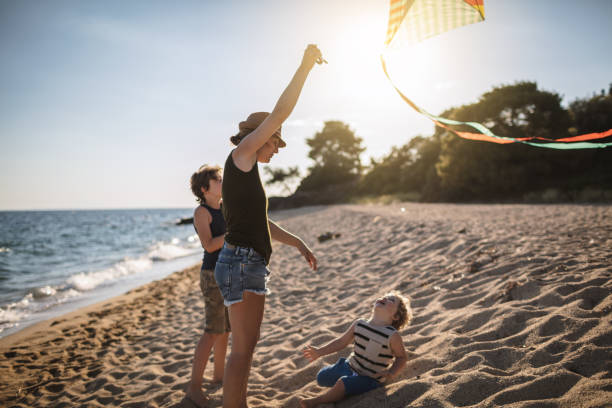 istock Mother and her sons flying a kite at the beach 956788078