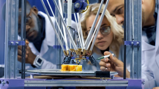 Researchers watching 3-D printing machine in process Interested multiethnic scientists gathering around 3-D printer and watching process of model production in laboratory. action plan three dimensional shape people stock pictures, royalty-free photos & images