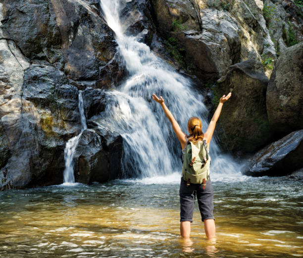 istock Female hiker looking at waterfall 956795878