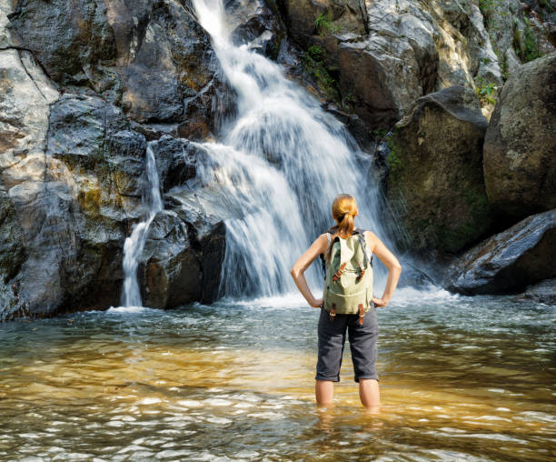 istock Female hiker looking at waterfall 956797022