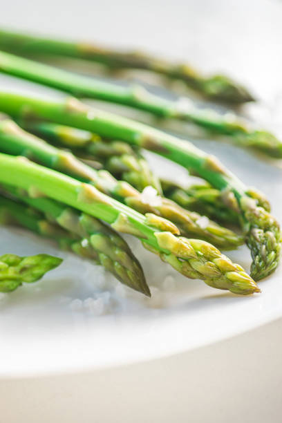 istock Ready to eat asparagus with big sea salt on a white plate 956800266