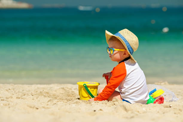 istock Two year old toddler playing on beach 956804552