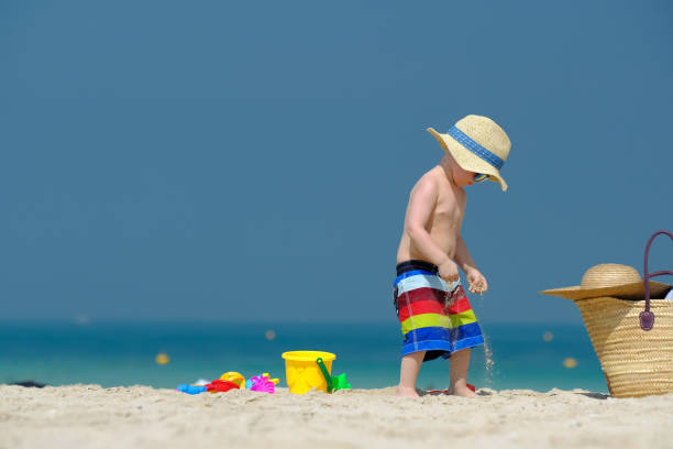 istock Two year old toddler playing on beach 956804564