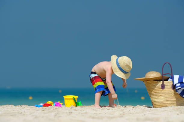 istock Two year old toddler playing on beach 956804566