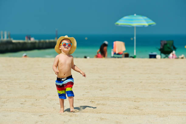 istock Two year old toddler boy running on beach 956804568