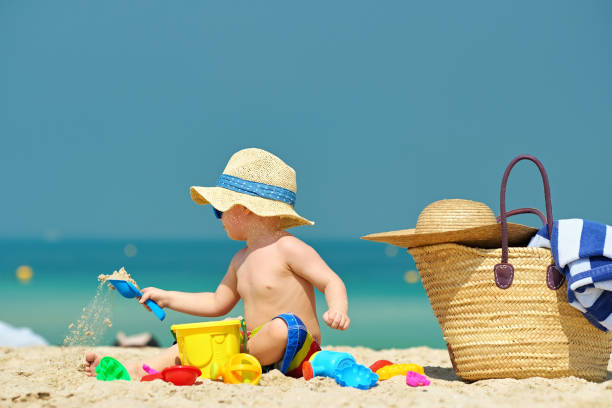 istock Two year old toddler playing on beach 956804578