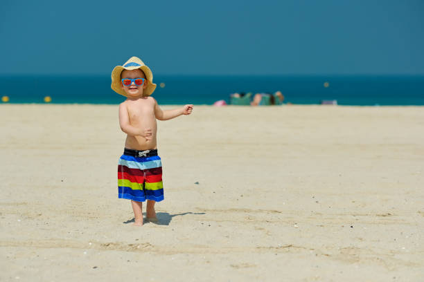istock Two year old toddler boy running on beach 956804584