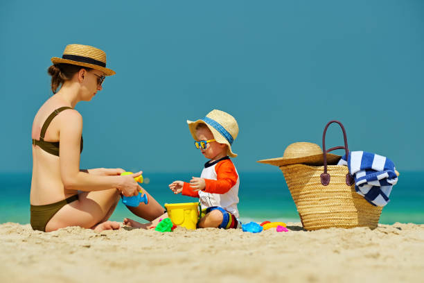 istock Toddler boy playing with mother on beach 956804594