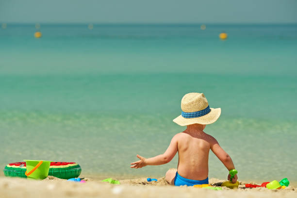 istock Two year old toddler playing on beach 956815376
