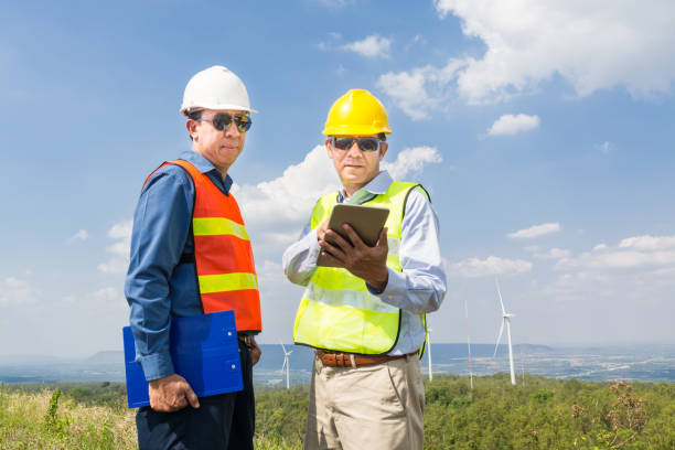 inżynier i architekt dyskutują o cyfrowym tablecie bezprzewodowym - alternative energy electricity wind turbine team zdjęcia i obrazy z banku zdjęć