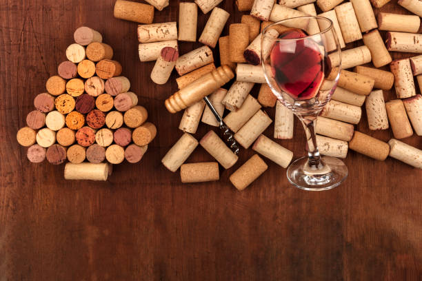 istock Glass of red wine with corks and corkscrew on a dark rustic background, with a handmade Christmas tree and copy space 956818964