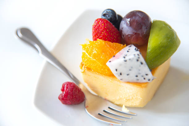 Slice of delicious cheesecake with fruit on White plate.