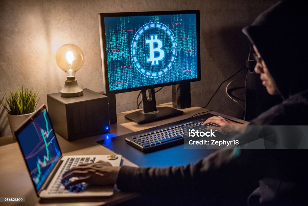 Hacker man using laptop and computer with Bitcoin green binary graphic and cryptocurrency candlestick graph price on monitor screen Hacker man using laptop and computer with Bitcoin green binary graphic and cryptocurrency candlestick graph price on monitor screen. Cyber crime digital currency laundering concept Cryptocurrency Stock Photo
