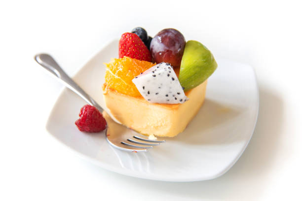 istock Slice of delicious cheesecake with fruit on White plate. 956823560