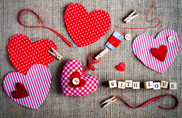 istock Red polka dot textile hearts on burlap. Free space for your text 956830432