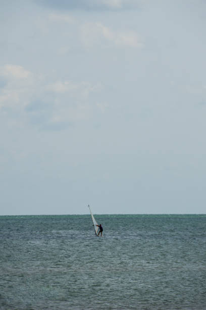 istock Windsurfing. Surfer exercising in calm sea or ocean. 956831198