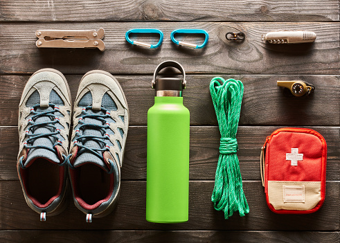 Travel items for hiking tourism flat lay still life over wooden background