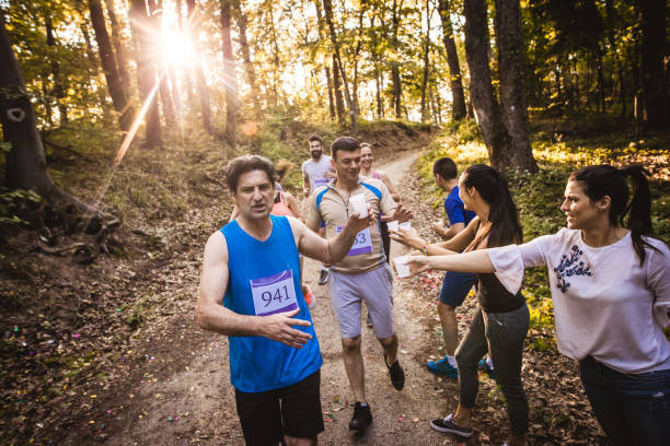 istock Marathon runners taking fresh water from volunteers during a race in nature. 956837210