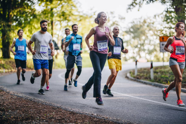 istock Large group of marathon runners having a race on the road. 956840034