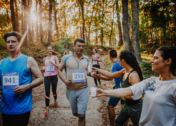 istock Athletic people running a marathon and refreshing themselves with water. 956840338