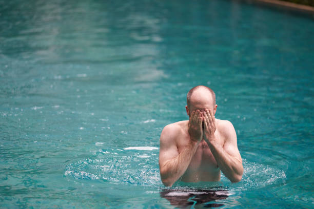 istock Fit Middle aged man relaxing in swimming pool 956840428