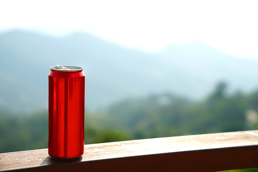 Red aluminium can with background of mountain layers