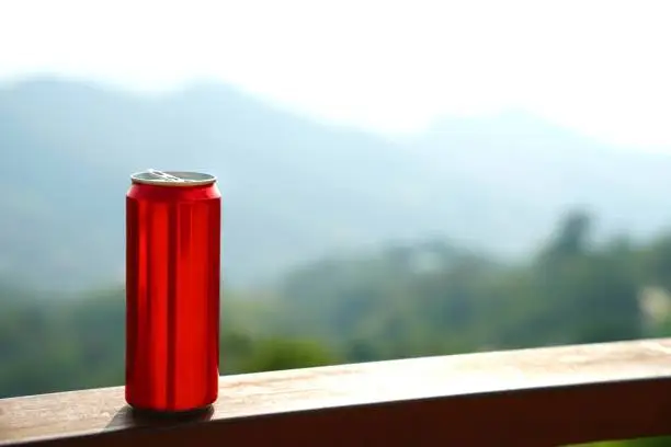 Photo of Red aluminium can with background of mountain layers