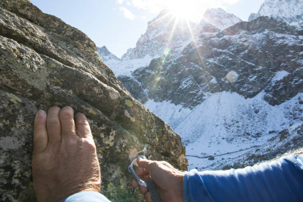 istock POV past climber hands placing safety gear in rock 956845126