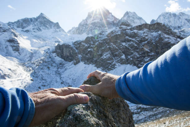 istock POV past climber hands on rock to mountains in distance 956845134